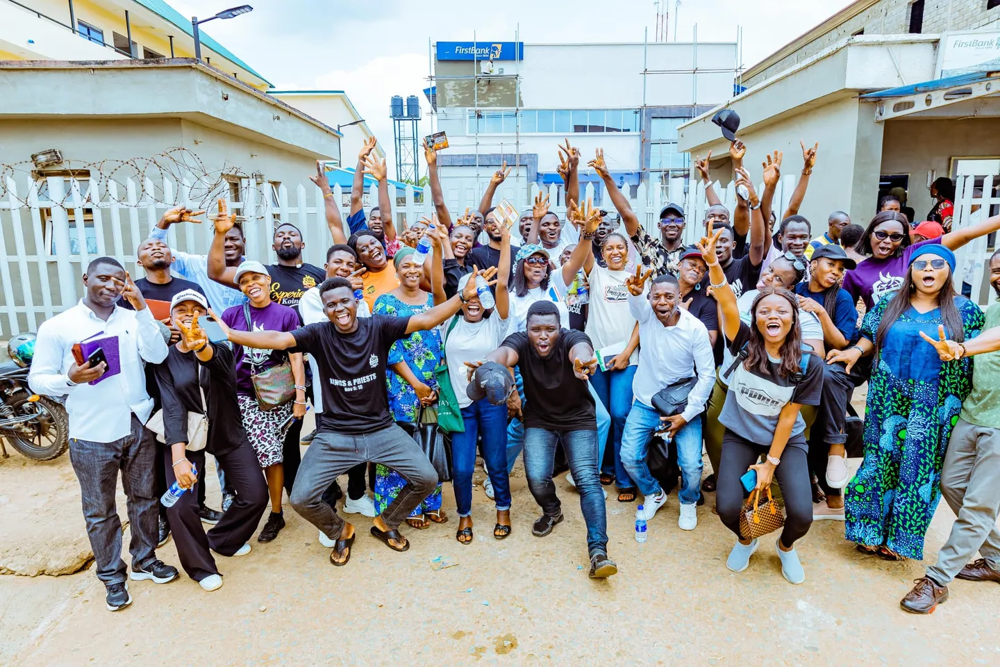 A joyful KSOM outreach team celebrating together with hands raised